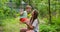 Happy family, mother and child play on wooden swing in garden under tree