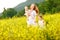 Happy family of mother and children run in the meadow of yellow