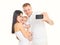 Happy family, mother and father with baby makes self portrait on smartphone