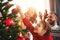 Happy family mother, father and child daughter decorate Christmas tree