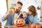 Happy  family mother father and child son prepare for Halloween decorate  home with pumpkins and  laughing, play and scare  with