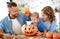 Happy  family mother father and child son prepare for Halloween decorate  home with pumpkins and  laughing, play and scare  with