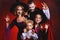 Happy family mother father and children in costumes and makeup on  Halloween on dark red background