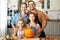 Happy family mother, father and children with pumpkin during celebration, preparing home Halloween decorations