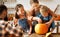 Happy family mother, father and kids to remove pulp from from pumpkin while carving jack o lantern with family