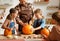 Happy family mother, father and kids to remove pulp from from pumpkin while carving jack o lantern with family