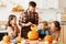 Happy family mother, father and kids to remove pulp from from pumpkin while carving jack o lantern with family