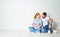 happy family mother, father of a newborn baby on floor near blank wall