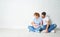 happy family mother, father of a newborn baby on floor near blank wall