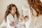 Happy family mother and little daughter in bathrobe makes manicure, laugh  on Spa day at home