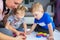 Happy family of mother and toddler twins are painting