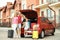 Happy family near car trunk with suitcases