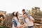 Happy family near horses at a farmer& x27;s ranch at sunset