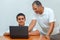 Happy family old grandfather and grandson on laptop.Elderly teacher trainer and teen pupil boy.