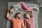 Happy family with one child lying together on grey knitted carpet