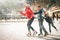 Happy family outdoor ice skating at rink. Winter activities