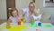 Happy family paints colors. Happy little childs making colorful color handsprint on the white paper. A little cute happy