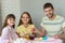 Happy family paints easter eggs at the table and looked joyfully into the frame