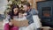 Happy family parents and kid reading book and talking on Christmas day at home