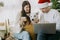 Happy family with pet shopping online or chatting  on laptop, celebrating christmas at home