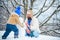 Happy family plaing with a snowman. Fathers day. Father and his son playing outdoors. Winter scene on white snow