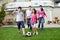 Happy family playing football in their backyard