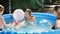 Happy family playing with toy boat ship with little boy. in outdoor swimming pool. Concept of happy and cheerful family