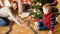 Happy family playing with toy railroad on Christmas morning. Child receiving presents and toy on New Year or Xmas