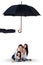 Happy family playing under umbrella in studio