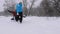 Happy family playing in winter in the Park for Christmas holidays. Funny mom and daughter ride dad on a sled in the snow