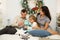 Happy family portrait on Christmas, mother, father and child sitting on bed and lighting a candle at home, chritmas