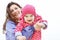 Happy family portrait. Laughing faces, mother holding adorable child baby girl smiling and hugging. Mom and daughter outdoors