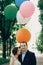 Happy family portrait, newlywed couple hugging in a sunny park in the summer, handsome groom looking at happy bride with balloons