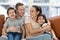 Happy family with preschooler kids relaxing on couch