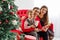 Happy family reads a book near a Christmas tree