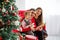 Happy family reads a book near a Christmas tree