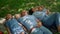 Happy family relax lying on picnic blanket close up. People rest on green lawn.