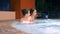 Happy family relaxing in outdoor jacuzzi. two children teenagers relaxing in hot water near the pool.