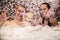 Happy family relaxing in the spa center with a child swims in the pool