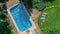 Happy family relaxing by swimming pool, aerial drone view from above of parents and kids have fun on vacation, family weekend