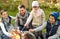 Happy family roasting marshmallow over campfire