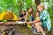 Happy family roasting marshmallows in the woods