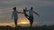 Happy family running in the field at sunset. Silhouette of a family on a summer evening. The concept of love of family