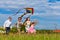 Happy family running on meadow with a kite