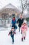 Happy family running out of the porch of the Christmas decorated house outdoor