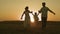 Happy family runs at sunset in sky, mother and father play with child in active jumps, childhood dream of being with mom