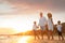 Happy family on sandy beach near sea at sunset