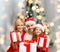 Happy family in santa helper hats with gift boxes