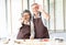 Happy family senior couple holds mold for cookies on eyes place making eyewear having fun in the kitchen at home.Happy family and