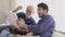 Happy family with senior father talking with son and looking paper together with excited on sofa